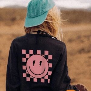 Girls Youth Black Sweater with Pink Smiley Checkered Design.